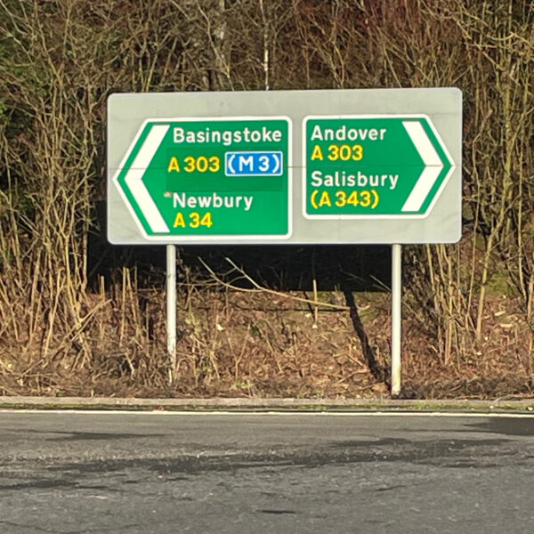 View of road from the storage facility featuring road signs showing Basingstoke, Newbury and Andover